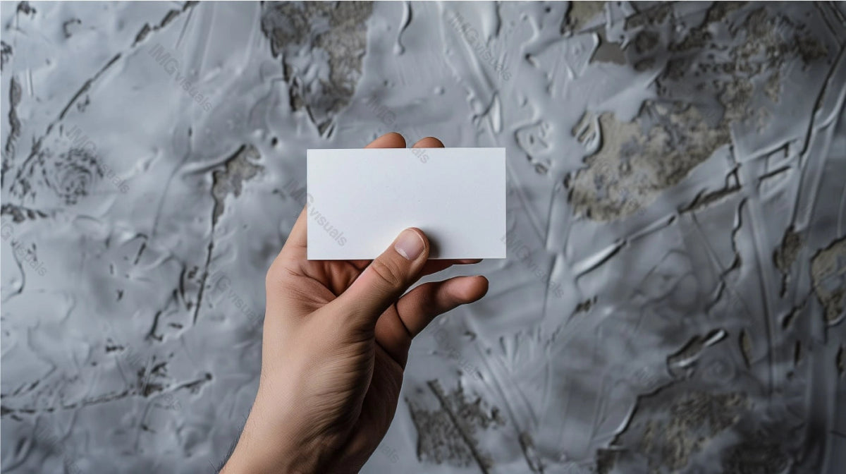 Hand holding blank white card mockup against grey paint textured wall, ai generated. Businesscard template advertising image. Workshop garage. Professional mock up product photorealistic